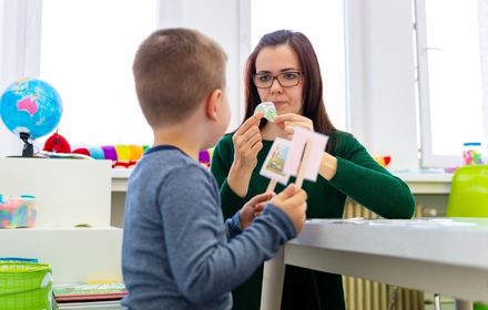 uma criança e uma adulta em uma sala lúdica de terapia